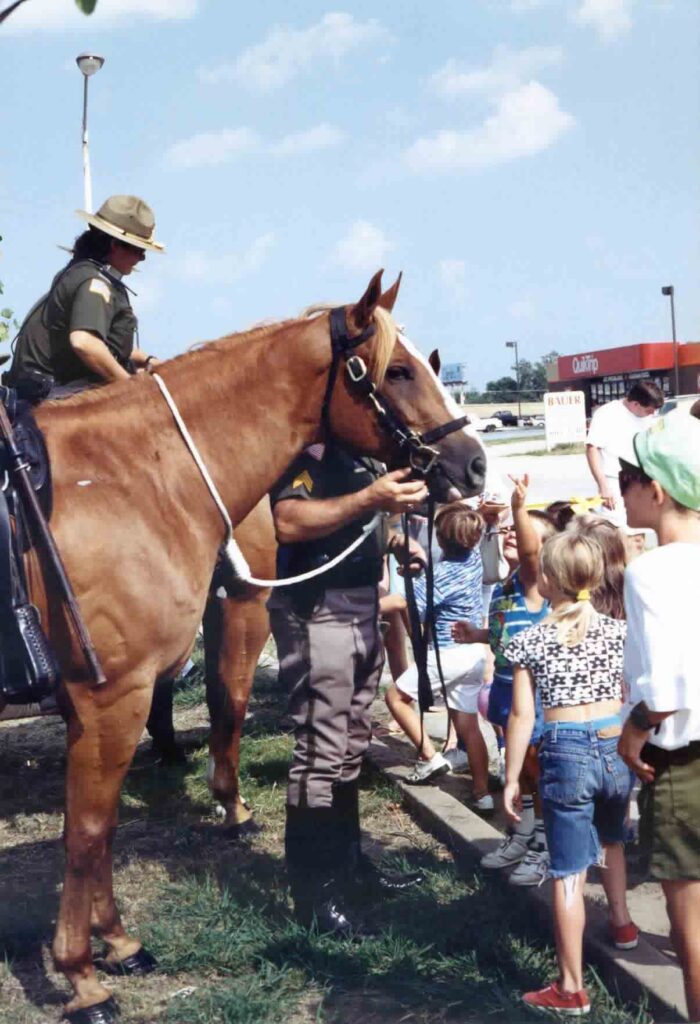 Children gather around a mounted patrol horse