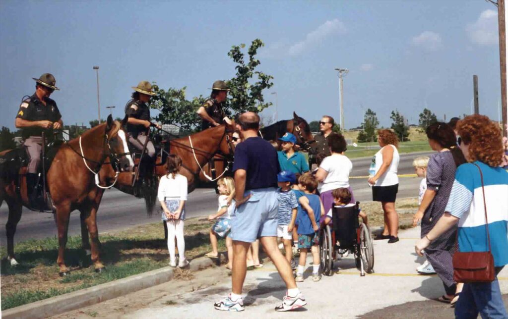 Mounted officers visit with families along a roadside