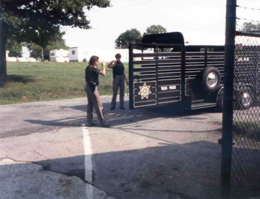 Two officers stand beside the Tulsa Police horse trailer