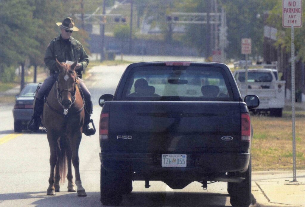 Mounted officer behind a stopped pickup truck