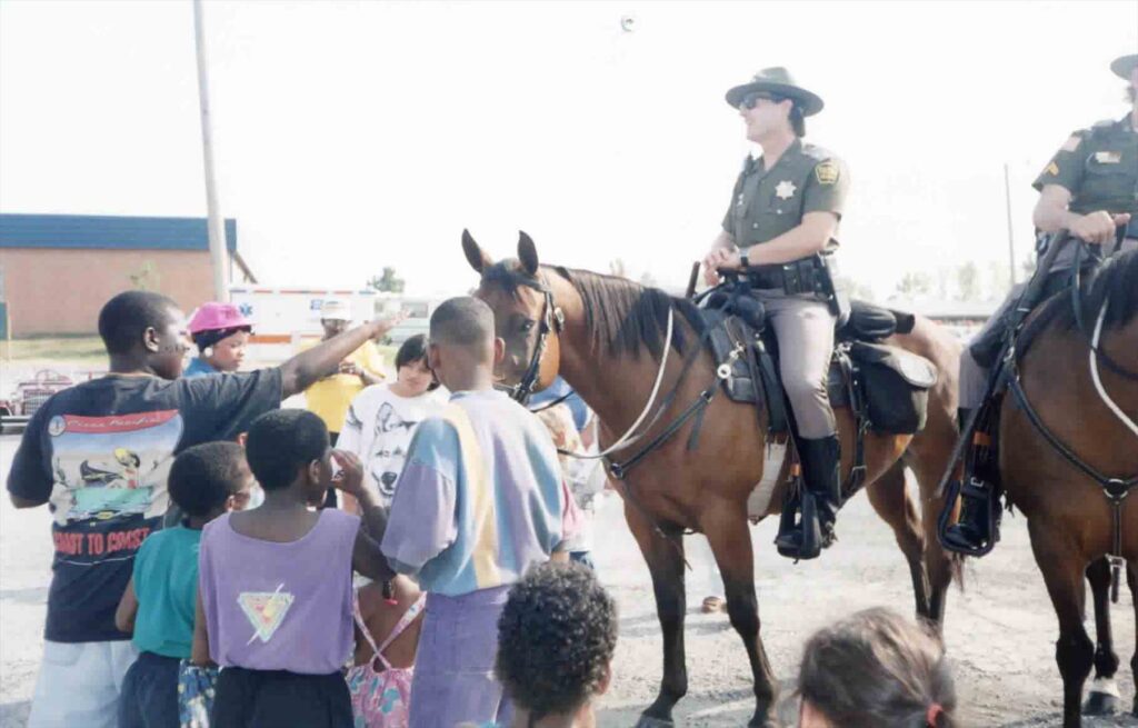 Children crowd around Tulsa mounted officers in the summer of 1993